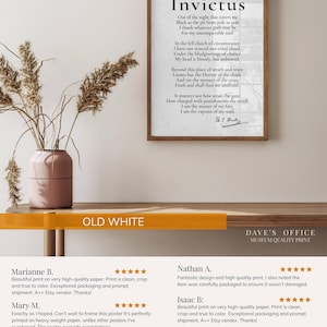 The image is a framed poster with a poem titled "Invictus" by B. M. W. Moore. The poster is hanging on a wall, and there is a vase with dried flowers nearby. The image also includes a few reviews from people who appreciate the quality and presentation of the poster.