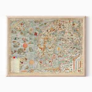 May include: A framed vintage map print featuring a detailed depiction of Scandinavia and surrounding areas. The map is in shades of blue, beige, and brown, with illustrations of ships, sea creatures, and compass roses. The frame is a light wood color.