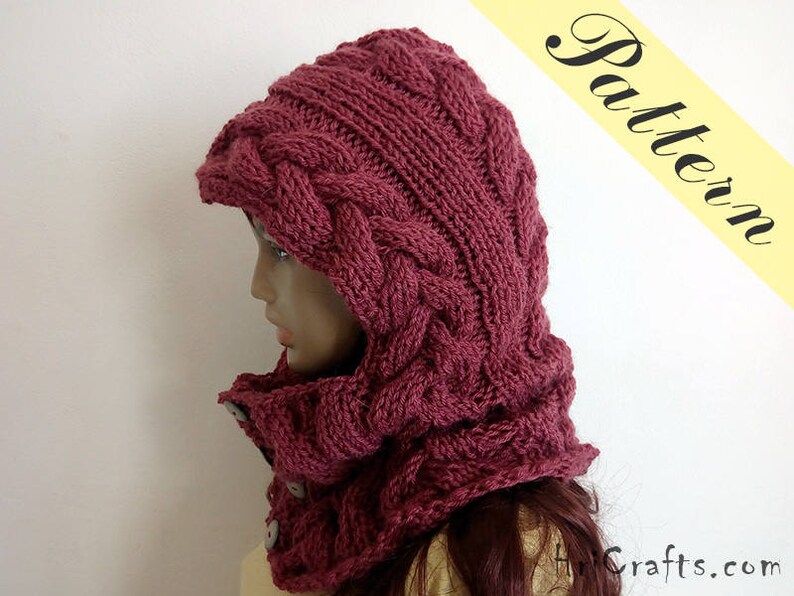 May include: A burgundy knitted hooded cowl with a cable knit pattern. The cowl is made of soft yarn and has a warm, cosy feel.