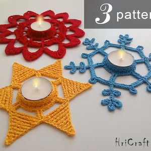 May include: Three crocheted candle holders in different patterns: a red flower, a blue snowflake, and a yellow star. Each holder features a small tea light candle.