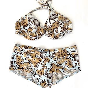 May include: A brown and blue floral print bikini top and bottom. The top is a halter style with a tie closure at the neck. The bottom is a high-waisted style with a full coverage fit.