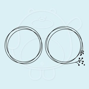 May include: Two black outlined circles with a floral design on the right side. The floral design includes a stem with leaves and berries.