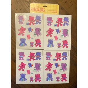 May include: Four sheets of self-adhesive stickers featuring cartoon bears in pink, purple, and blue. The bears are in different poses. The sticker sheet packaging is yellow with the word "STICKERS" printed on it.
