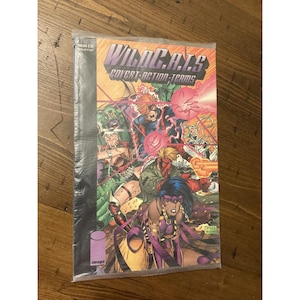 May include: A sealed comic book titled "WildC.A.T.s Covert Action Teams" with a colorful illustration of various characters in action. The comic book is in a clear plastic sleeve, with the Image Comics logo visible.