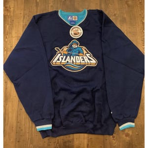 Op de afbeelding: Marineblauwe Starter-sweatshirt met het logo van de New York Islanders. Het logo toont een hockeyspeler met een hockeystick. De sweatshirt heeft een turquoise en witte afwerking op de kraag en manchetten. Een Starter-label is zichtbaar.