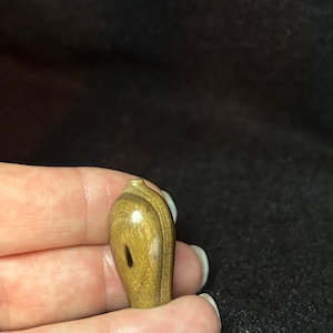 May include: A small, wooden, brown and black vase with a smooth, polished finish.