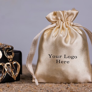 Conjunto de 100 bolsas de embalagem de joias personalizadas de cetim bege, bolsa de cetim com cordão, pequena bolsa de cosméticos, bolsa de ganhos