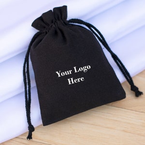 May include: A black drawstring bag with a white logo that says "Your Logo Here".