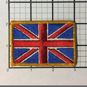 May include: A red, white, and blue embroidered patch of the Union Jack flag with a gold border.
