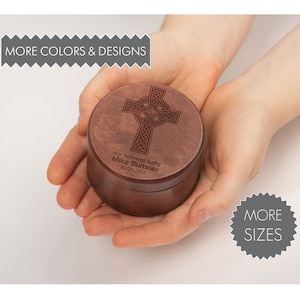 May include: A wooden box with a Celtic cross design engraved on the lid. The box is personalized with the text "our beloved baby Mike Sumner 05/21/2022".