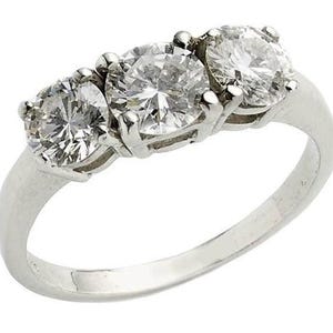 May include: A silver ring with three round, clear diamonds set in a row.
