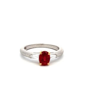 May include: A silver ring with a red oval ruby gemstone and two smaller diamond accents.