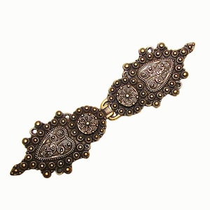 May include: Ornate antique bronze-tone clasp with intricate filigree and dot detailing. The clasp features two decorative end pieces connected by a central hinge. The design includes teardrop and circular shapes, perfect for vintage-inspired projects.