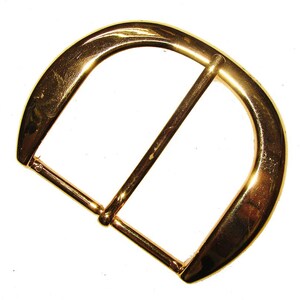 May include: A gold-toned metal buckle with a D-ring shape. The buckle is designed for belts or straps.