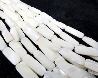May include: A strand of white rectangular mother of pearl beads. The beads are smooth and have a natural iridescent sheen.