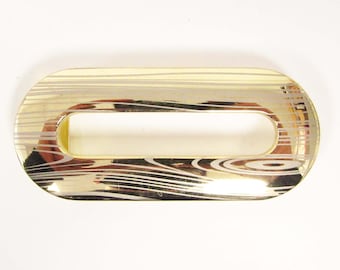 May include: Gold-toned oval-shaped metal buckle with a woodgrain pattern. The buckle has a rectangular opening in the center.
