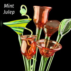 May include: A collection of glass flower sculptures featuring red tulip-shaped blossoms, a green and blue striped funnel-shaped piece, and a green leaf-shaped element. The text Mint Julep is visible in the upper left corner against a black background.