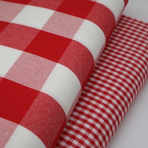 May include: Two red and white gingham fabrics, one with larger squares than the other.