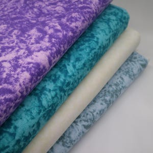 Puede incluir: Cuatro muestras de tela en diferentes colores y patrones. La muestra superior es de color morado claro con un patrón de mármol. La segunda muestra es de color azul turquesa con un patrón de mármol. La tercera muestra es de color amarillo claro con un patrón de mármol. La muestra inferior es de color azul claro con un patrón de mármol.