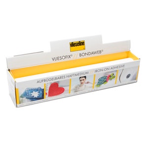 May include: A white box with yellow accents and the text "Vliesofix&reg; // Bondawweb&reg;" and "AUFB&Uuml;GELBARES HAFTMEDIUM // IRON-ON ADHESIVE". The box contains a roll of white fabric adhesive.
