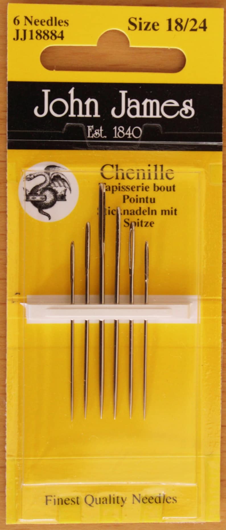 May include: A pack of six John James Chenille needles, size 18/24, displayed on a yellow card. The packaging features the text 6 Needles, JJ18884, Size 18/24, John James, Est. 1840, Chenille, Tapisserie bout Pointu, and Finest Quality Needles.