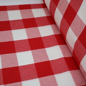 May include: Red and white checkered fabric with a large square pattern. The fabric is folded and rolled up.