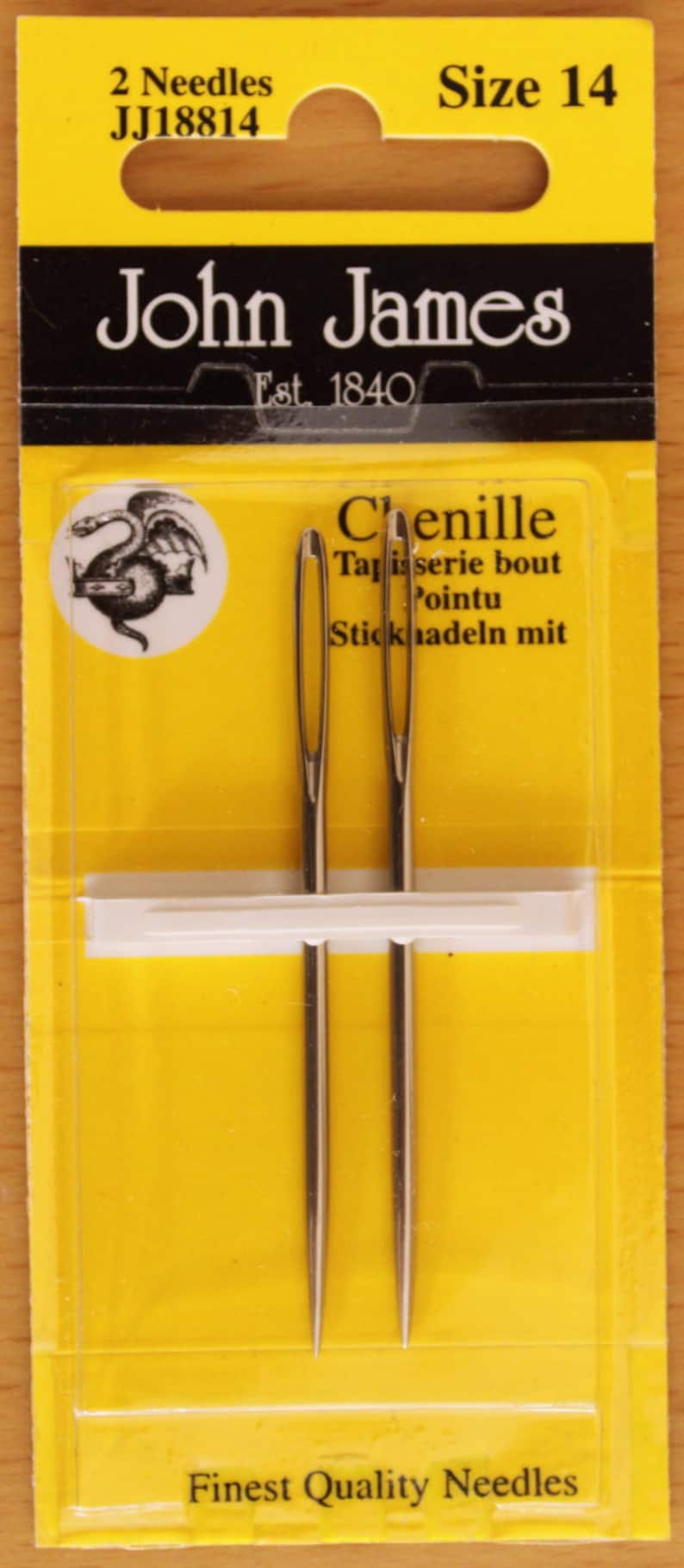 May include: Two silver-coloured John James size 14 chenille needles packaged in a yellow and black card. The packaging features the text 2 Needles, JJ18814, Size 14, John James, Est. 1840, Chenille, Tapisserie bout Pointu, Sticknadeln mit, and Finest Quality Needles.