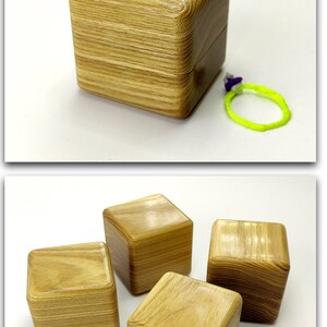 May include: Four wooden boxes with a light brown wood grain finish. The boxes are square and have a smooth, polished surface. The boxes are arranged in a group, with one box in the center and three boxes surrounding it.