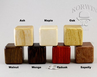 May include: Eight wooden ring boxes in different wood types: Ash, Maple, Oak, Walnut, Wenge, Paduak, Sapelly. The boxes are stacked on top of each other, with the top box being Ash and the bottom box being Sapelly.
