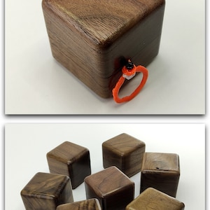 May include: Eight small, square, wooden boxes made of walnut wood. The boxes are arranged in a semi-circle on a white surface.