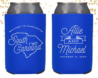 May include: Two blue can coolers with white text. One cooler says "Welcome to Charleston, South Carolina" with an outline of the state of South Carolina. The other cooler says "Allie and Michael, October 14, 20XX".