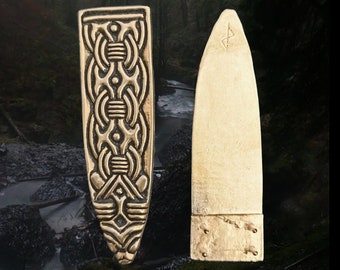 May include: Two gold-colored metal pieces, one with an intricate design and the other plain. The piece with the design has a pattern of interlocked circles and lines. The plain piece has a small inscription on the top.