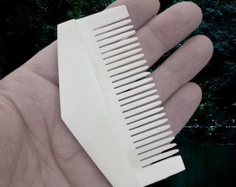 May include: White plastic comb with a triangular shape and a row of teeth on one side.