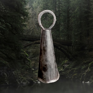 May include: A silver bell with a rounded top and a cone-shaped body. The bell has a loop at the top for hanging.
