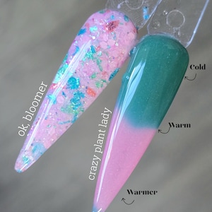 May include: Two nail polish swatches. One is light pink with iridescent glitter and the text "ok, bloomer". The other is teal that fades to pink with temperature-sensitive color change, labeled "crazy plant lady".