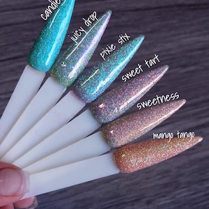 May include: A collection of six glitter nail polish swatches on white sticks. The colors include Candied, Juicy Drop, Pixie Stix, Sweet Tart, Sweetness, and Mango Tango. Each swatch has a different glitter color and is labeled with its name.