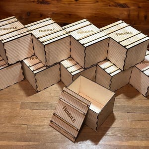 May include: A group of 10 wooden boxes stacked in a pyramid shape. The boxes are all labeled "FRAGILE" and have a wood grain pattern. One box is open and empty.
