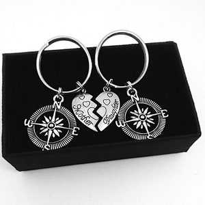 May include: Two silver keychains with compass charms and a broken heart charm that says "Mother" and "Daughter" on each half.