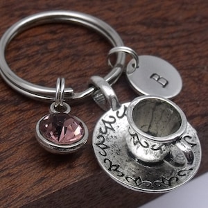 May include: Silver charm keyring with a teacup and saucer, a pink crystal charm, and a silver charm with the letter "B".