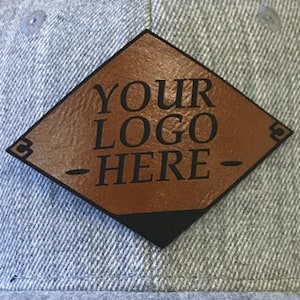 May include: A gray baseball cap with a brown leather patch that says "YOUR LOGO HERE" in black lettering.