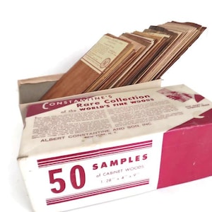 May include: A vintage box of 50 cabinet wood samples from Constantine's. The box is white with a red accent and text that reads "50 Samples of Cabinet Woods". The wood samples are various shades of brown.