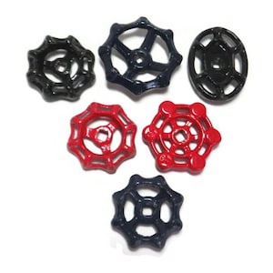 Peut inclure: Six poignées de vanne d'eau de style vintage en noir et rouge. Les poignées sont en métal et ont un design en étoile.