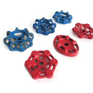 May include: Six vintage water valve handles, three red and three blue, with a decorative, openwork design.
