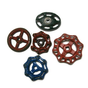 May include: Five vintage metal valve handles in various colors. The handles are round with a hole in the center and have a decorative design. The colors are red, green, and blue.