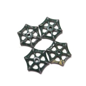 May include: Four antique green metal water valve handles with a starburst design. The handles are slightly worn and have a distressed look.
