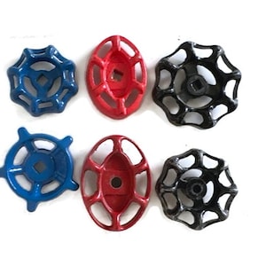 May include: Six vintage valve handles in blue, red, and black. The handles are made of metal and have a variety of shapes, including round and oval. The handles are arranged on a white background.