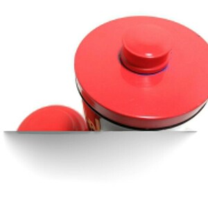 May include: Red metal container with a red lid and a black base. The lid has a small red knob on top.