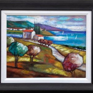 May include: A framed landscape painting featuring a coastal scene with white buildings, red roofs, and tall trees. A winding path leads toward a blue sea with white sailboats under a cloudy sky. The foreground includes colorful trees in shades of green, brown, and pink.