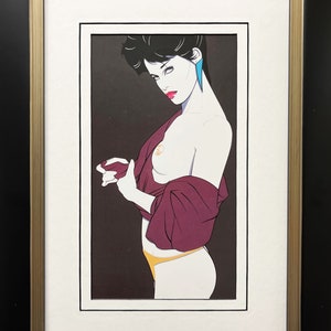 May include: A framed print of a woman with dark hair and a purple shirt. She is wearing a yellow undergarment and blue earrings. The background is black.