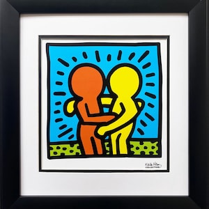 Puede incluir: Una impresi&oacute;n colorida de dos figuras abraz&aacute;ndose, una en rojo y otra en amarillo, sobre un fondo azul con contornos negros. La impresi&oacute;n se titula "Keith Haring Collection".